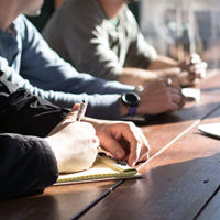 People writing at a desk